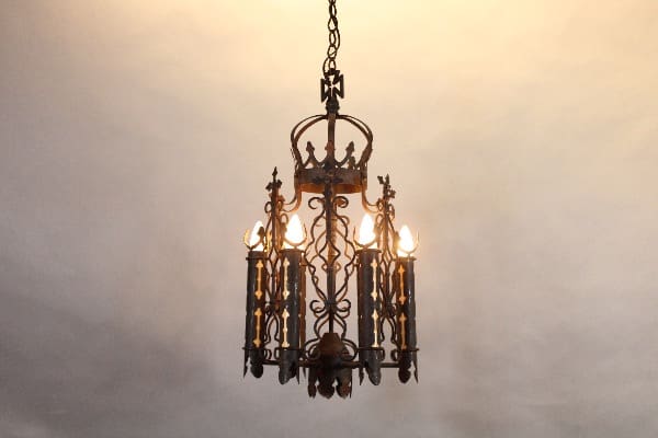 Ornate wrought iron chandelier with glowing lights.