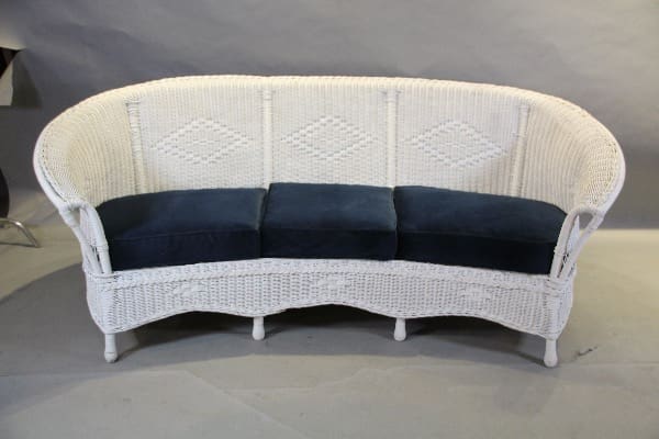 White wicker sofa with blue cushions.