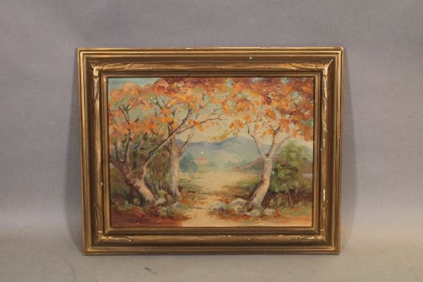 Framed autumn landscape painting with trees.