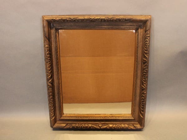 Ornate framed mirror with carved details.