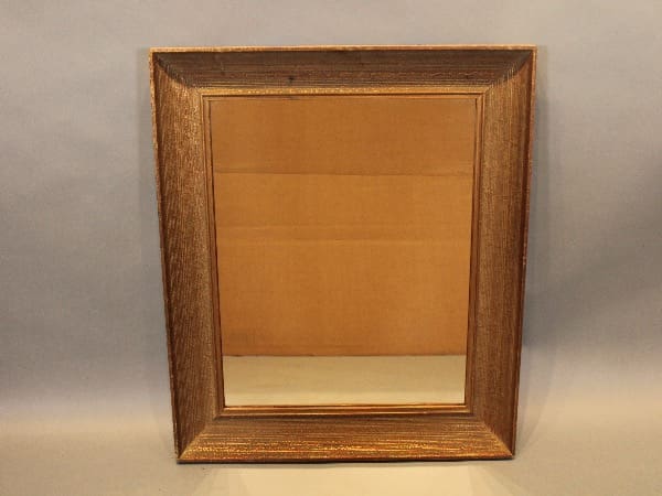 Wooden-framed mirror on plain background.