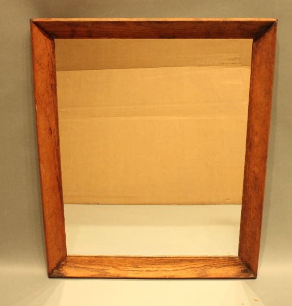 Rectangular wooden framed mirror on display.