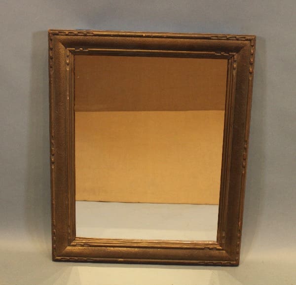 Antique mirror with ornate wooden frame.