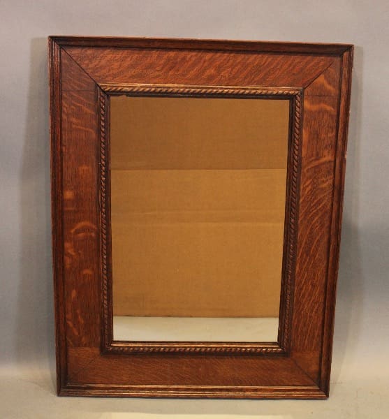 Wooden-framed mirror with ornate detailing.