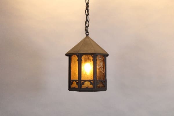 Hanging vintage lantern with glowing light bulb.