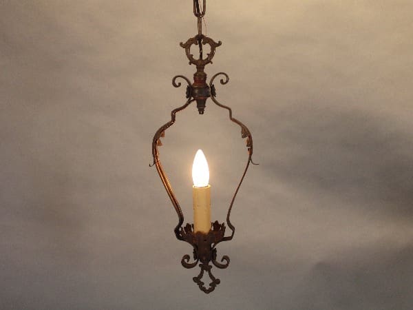 Ornate pendant light with candle-shaped bulb.