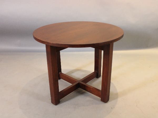 Round wooden table with cross legs.