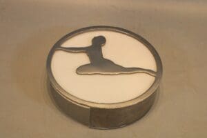 Metallic silhouette of a gymnast leaping sculpture.