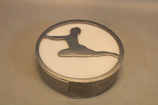Metallic silhouette of a gymnast leaping sculpture.