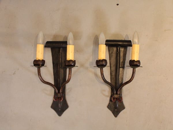 Two vintage wall sconces with candle bulbs.