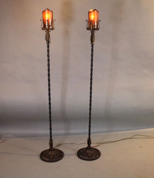 Two ornate vintage standing lamps, illuminated.