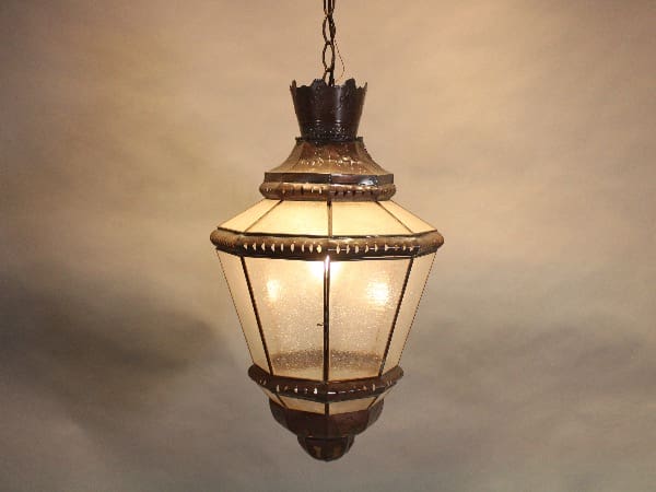 Vintage hanging lantern with illuminated bulbs.