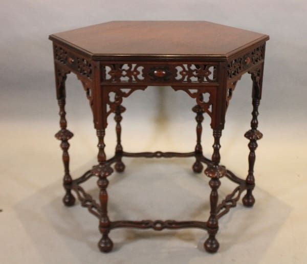 Ornate wooden hexagonal table with carvings.