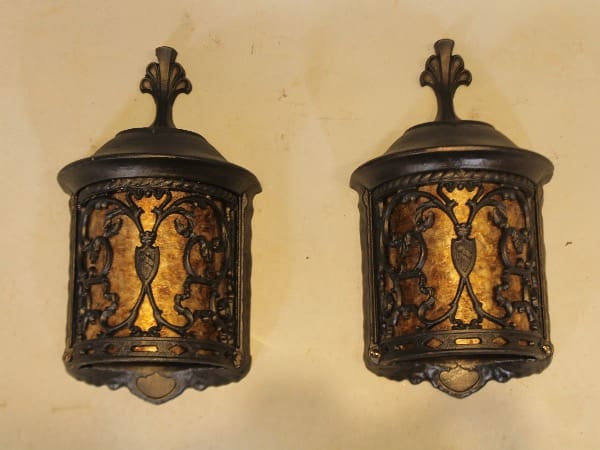 Two ornate vintage wall sconces with scrollwork.