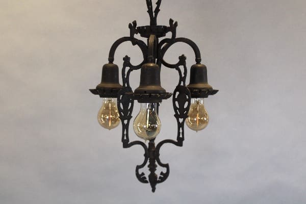 Vintage chandelier with exposed light bulbs.