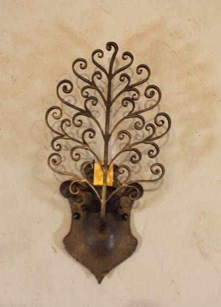 Ornate metal wall sconce with intricate design.