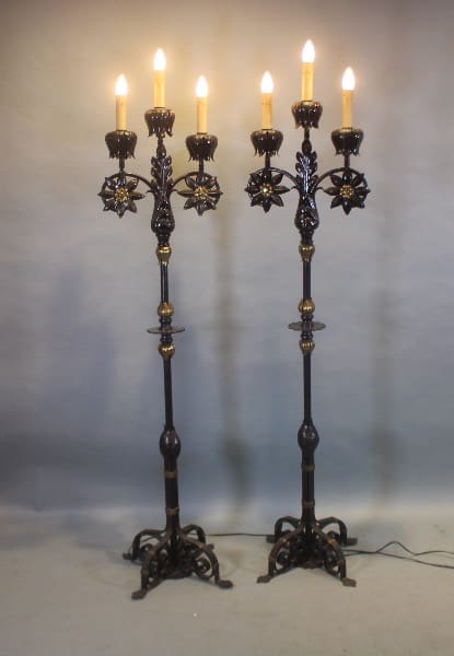 Two ornate floor lamps with lit bulbs.