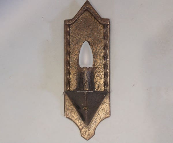 Vintage wall sconce with candle-shaped bulb.