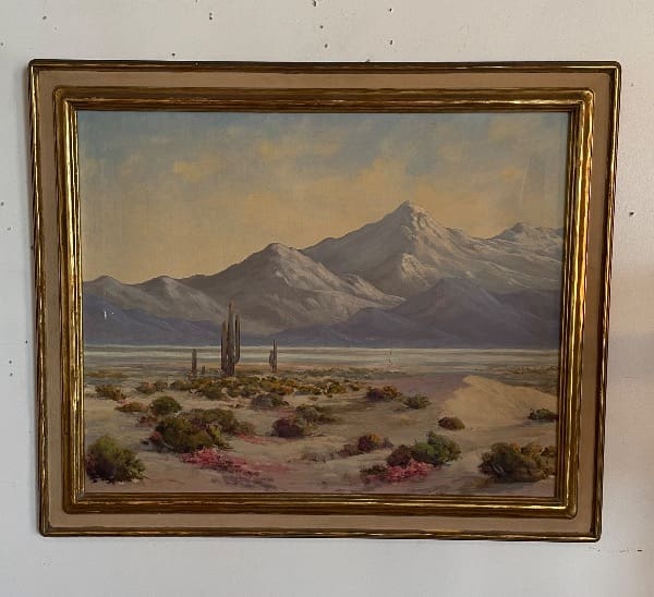 Mountain landscape painting in ornate gold frame.