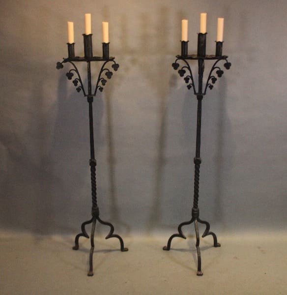 Two wrought iron candle stands with candles.