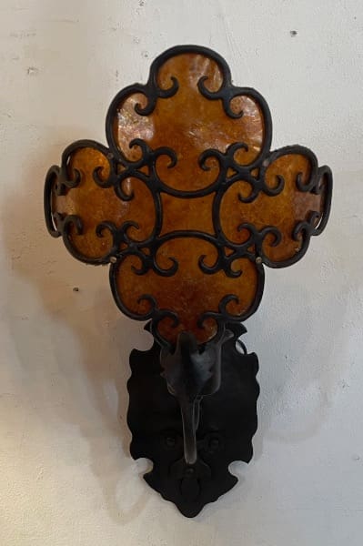 Ornate wall sconce with decorative metal design.