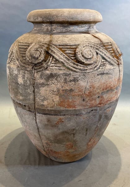 Ancient, textured ceramic vase with spiral design.