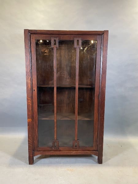 Wooden cabinet with glass doors and shelves.