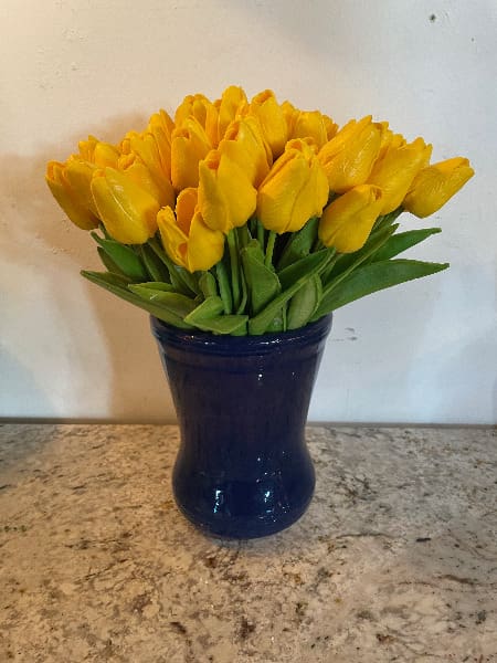 Yellow tulips in a blue vase.