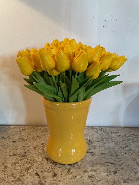 Yellow tulips in a matching vase.