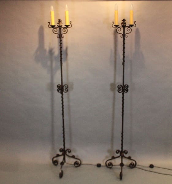 Two ornate wrought iron candle stands.