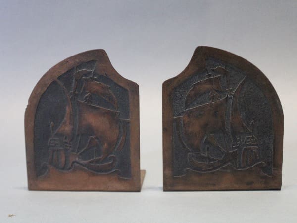Two engraved metal bookends with ship design.