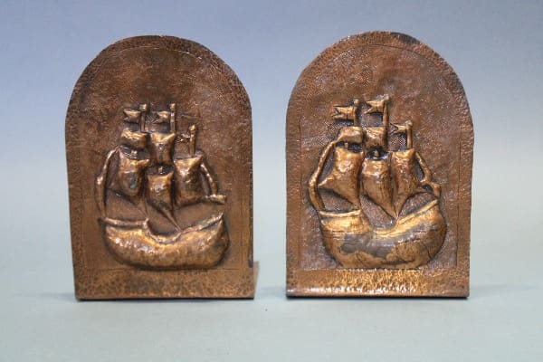 Bronze bookends with ship engravings displayed.