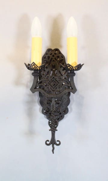 Ornate wall sconce with two candles.