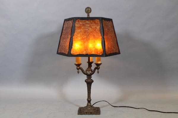 Ornate lamp with glowing amber lampshade.