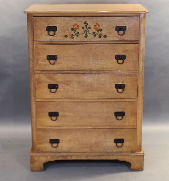 Vintage wooden chest with floral drawer design.