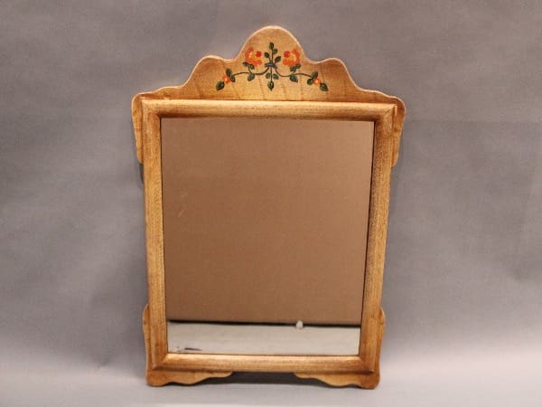 Wooden mirror with floral painted design.