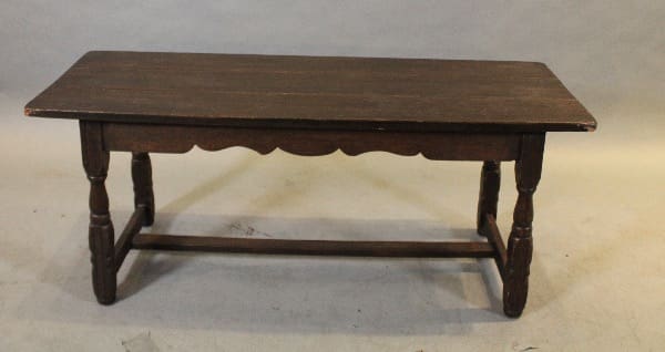 Wooden rectangular table with carved legs.