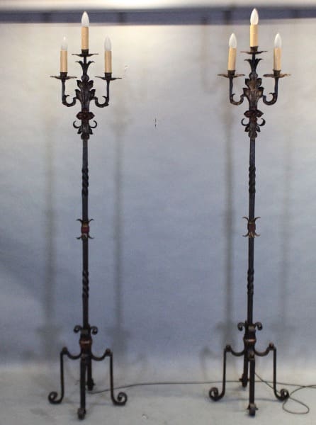 Two ornate wrought iron candelabras with candles.