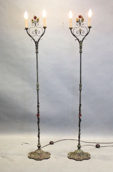 Two ornate metal floor lamps with candles.