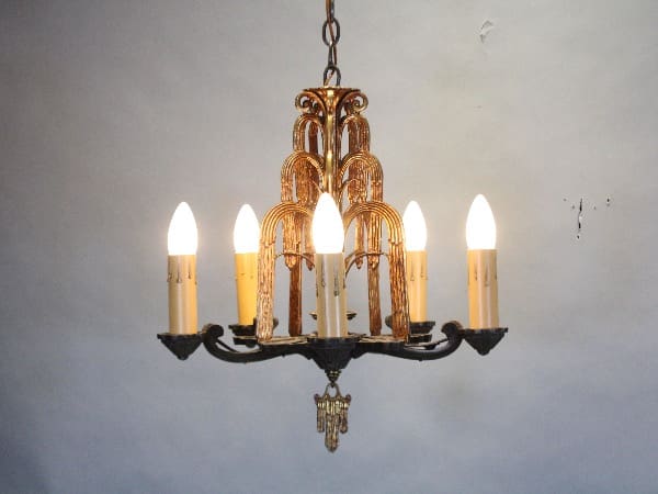 Vintage chandelier with six glowing bulbs.