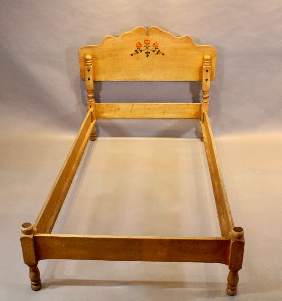 Vintage wooden bed frame with floral design.