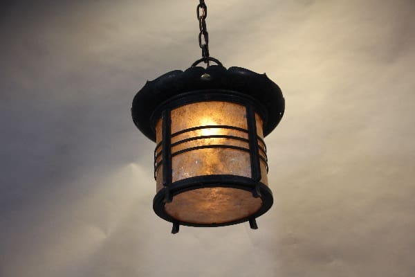 Hanging metal lantern with warm glow.