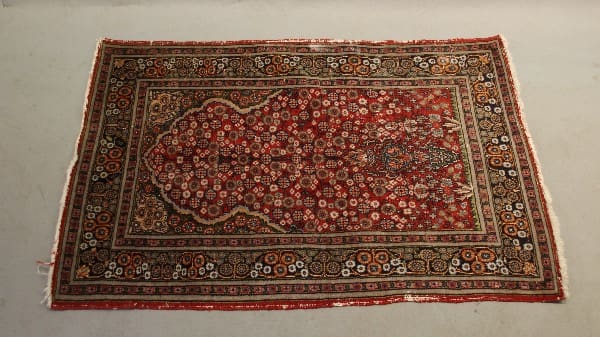 Ornate red and brown patterned area rug.