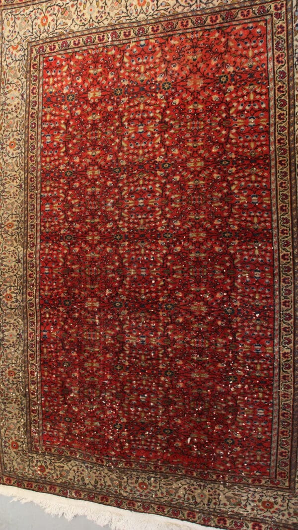 Red Persian rug with intricate floral pattern.
