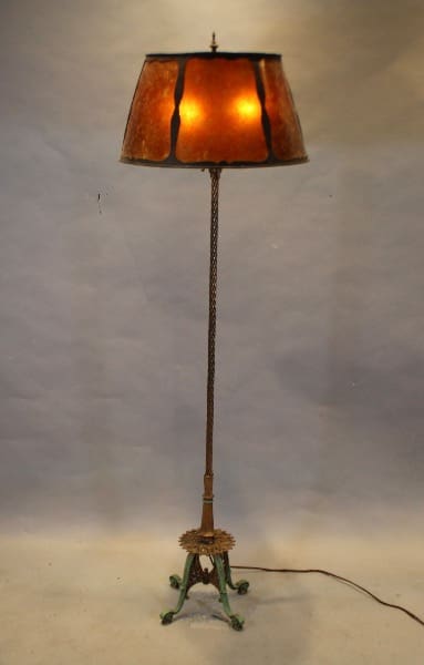 Vintage floor lamp with illuminated shade.