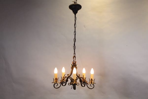 Ornate chandelier with six glowing lights.