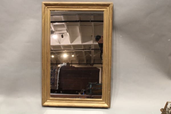 Rectangular wooden-framed mirror on wall.