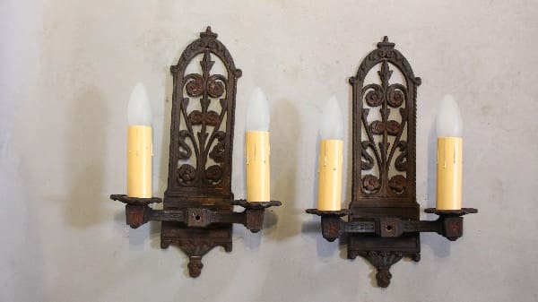 Two ornate vintage wall sconces with candles.