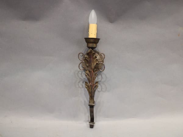 Ornate wall sconce with candle-shaped bulb.