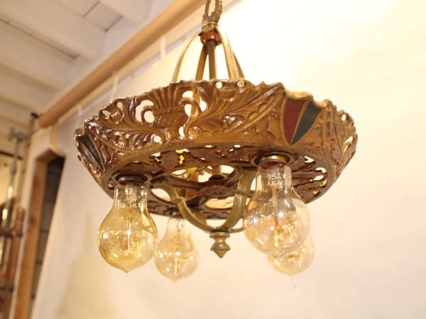 Ornate vintage chandelier with exposed light bulbs.